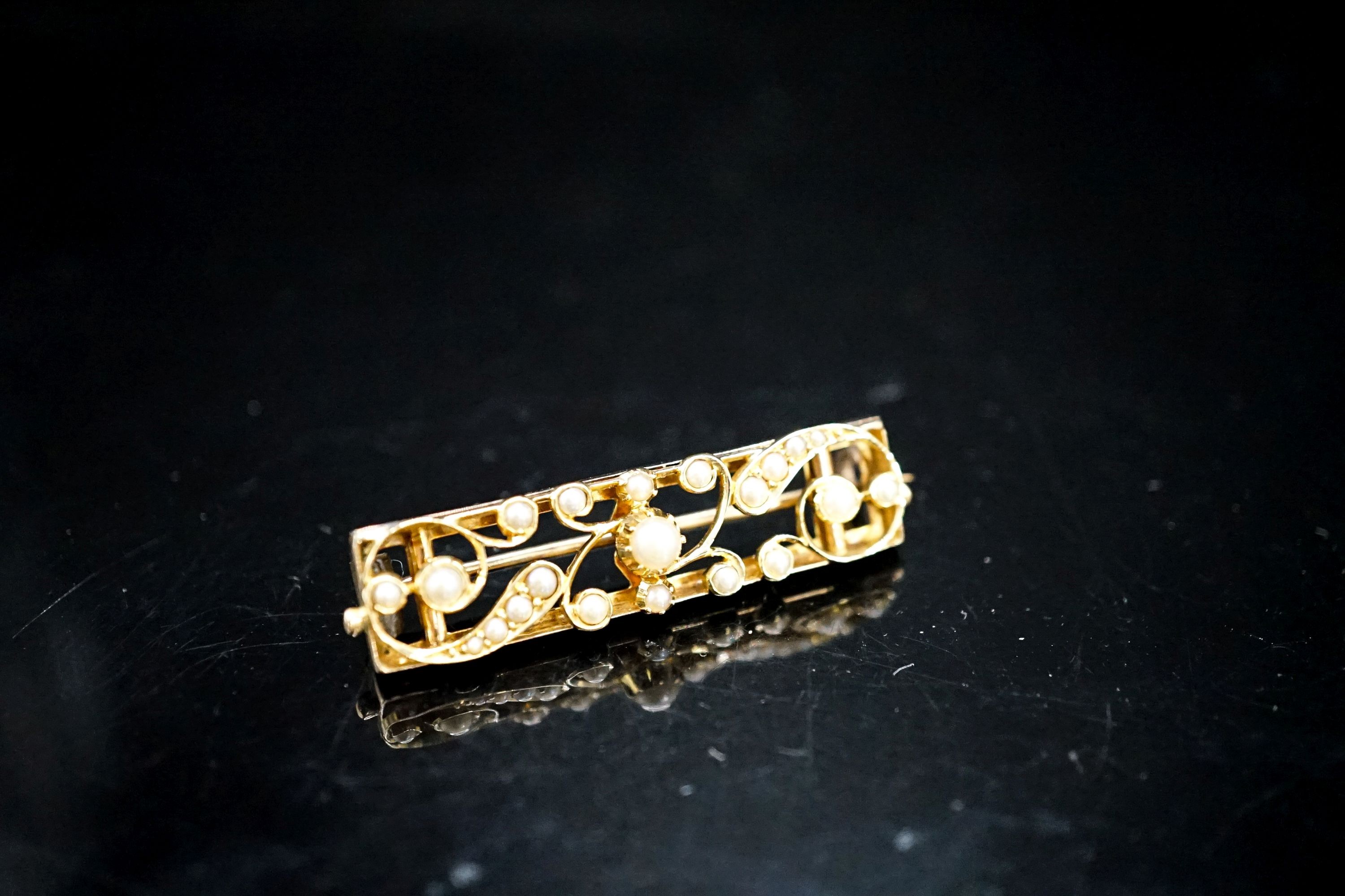 An early 20th century yellow metal and seed pearl set rectangular bar brooch, 38mm